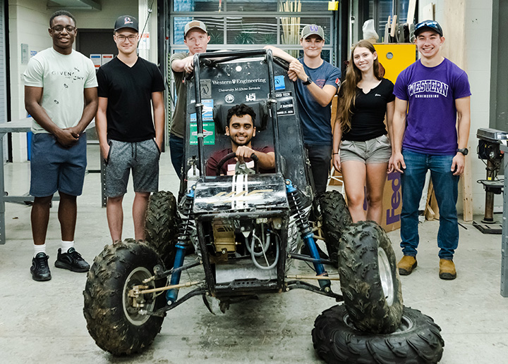 Students around a custom built off road vehicle
